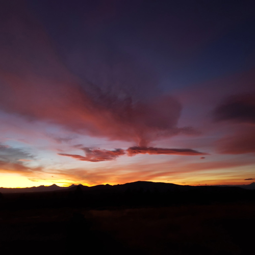 A red and violet sunset over a mountain skyline