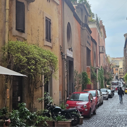A cobblestone street lined with ivy-covered buildings